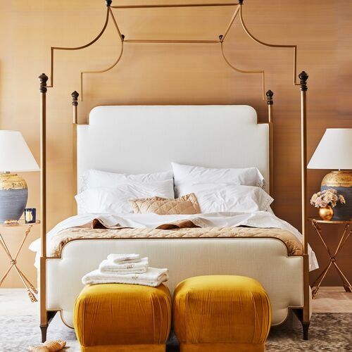 a bedroom with a bed, two stools and lamps on either side of the bed