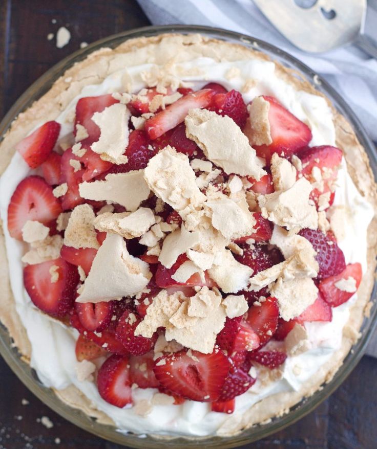 a pie topped with strawberries and whipped cream