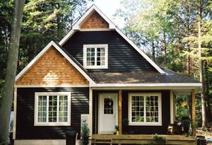 a black and white house in the woods