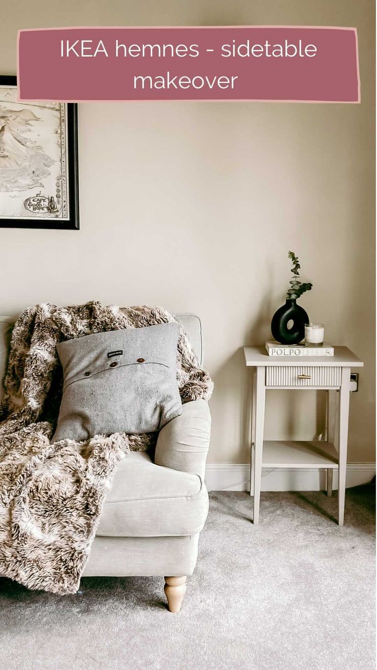 a white chair sitting in a living room next to a table with a vase on it