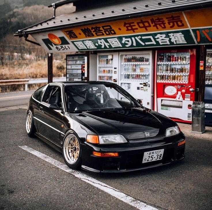 a black car parked in front of a store