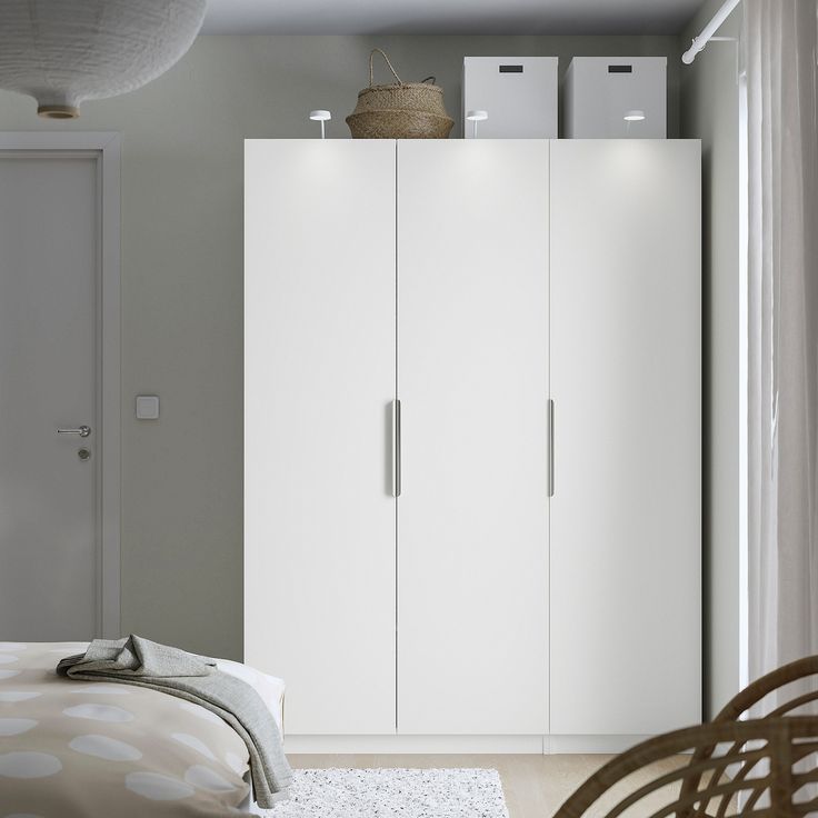 a bedroom with a bed and white cupboards