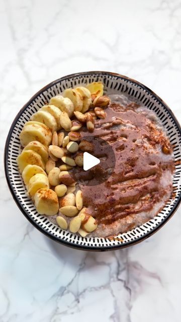 a bowl filled with bananas and nuts on top of a marble countertop next to a video player