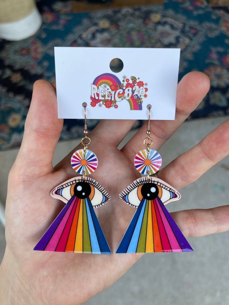 Step back in time to the psychedelic era with these 70s Retro Rainbow Eye Groovy Earrings. Inspired by the vibrant colors and mesmerizing patterns of the 1970s, these earrings feature a unique design that incorporates a rainbow eye motif. Crafted from lightweight acrylic, these earrings offer comfort without compromising on style. The hooks are made of stainless steel, coated in 18k gold for a touch of luxury, and are nickel-free to ensure a comfortable wearing experience. Product Details: Size: Retro Multicolor Jewelry For Festivals, Retro Dangle Earrings For Festivals, Multicolor Retro Festival Jewelry, Rainbow Retro Jewelry For Gift, Retro Rainbow Colored Jewelry Gift, Colorful Retro Earrings For Gift, Retro Rainbow Jewelry Gift, Retro Rainbow Jewelry For Gifts, Colorful Retro Earrings For Gifts