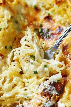 a close up of a plate of food with noodles and meats on it next to a fork