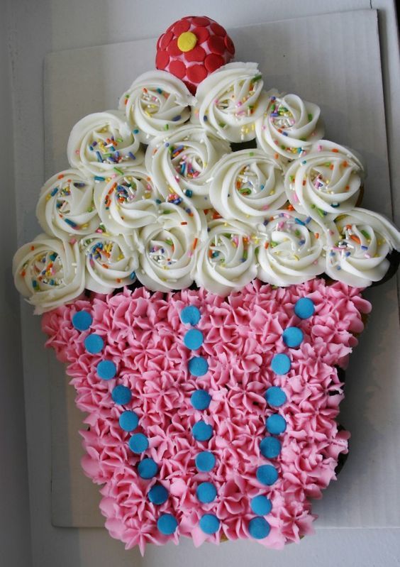 a cupcake shaped cake with icing and sprinkles on it's side