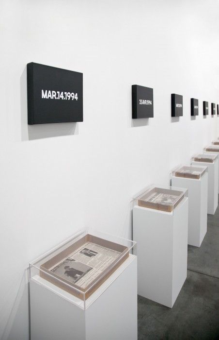 a row of white pedestals with black and white signs on the wall above them