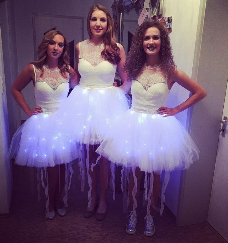 three women dressed in white dresses are posing for the camera