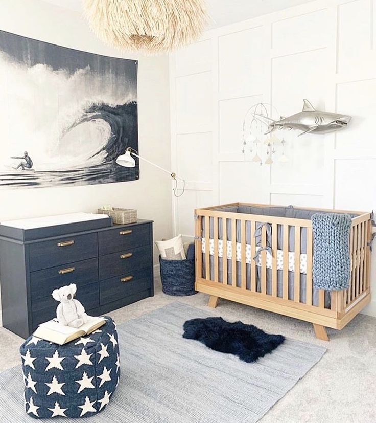 a baby's room with a shark painting on the wall and a crib