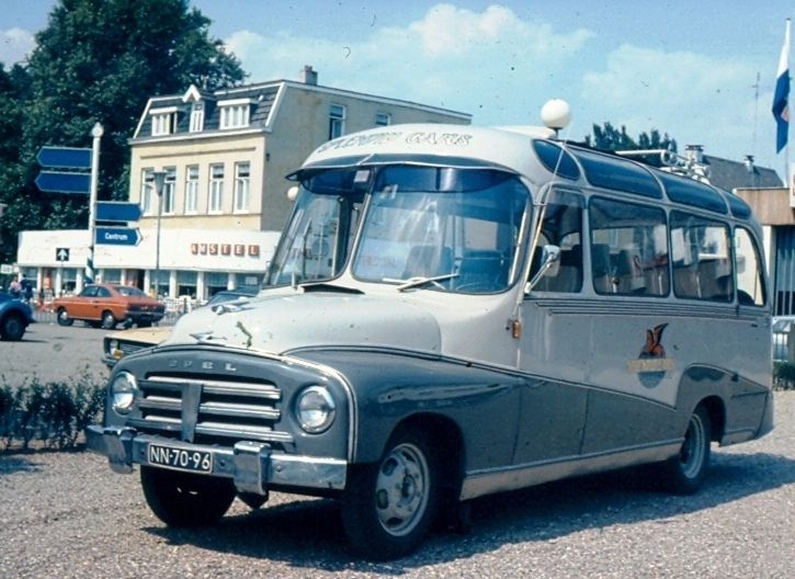 an old bus is parked on the side of the road