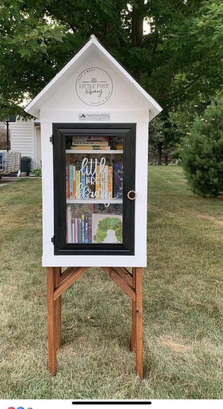 a little library in the middle of some grass