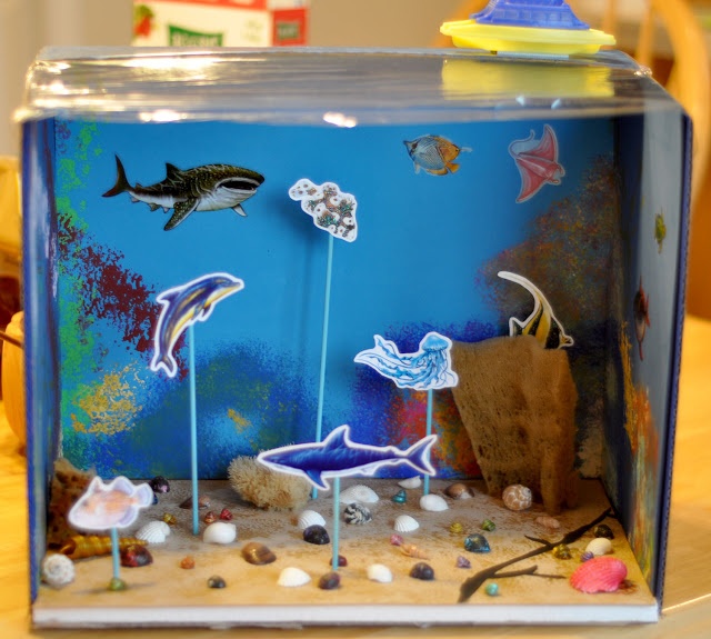 an aquarium filled with fish and rocks on top of a table