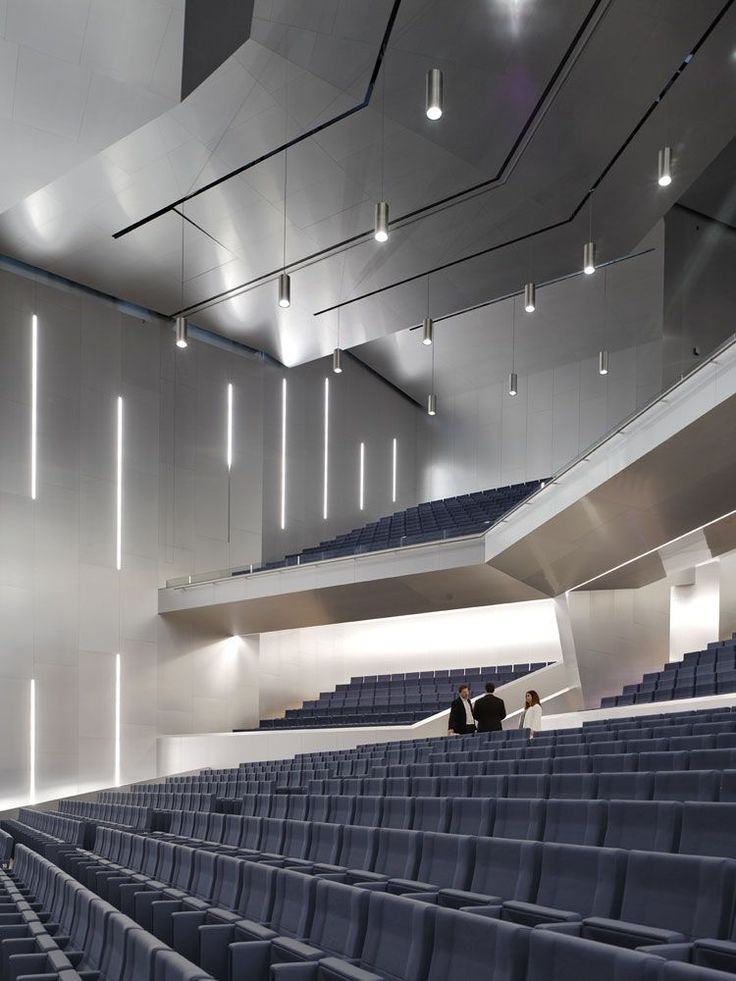 an empty auditorium with blue seats and white walls