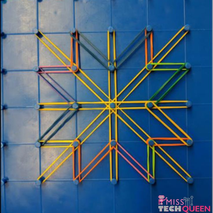 a colorful star on the side of a blue wall with yellow, orange and green sticks sticking out of it