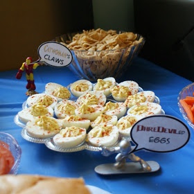 a table topped with lots of food next to a bowl of carrots and crackers