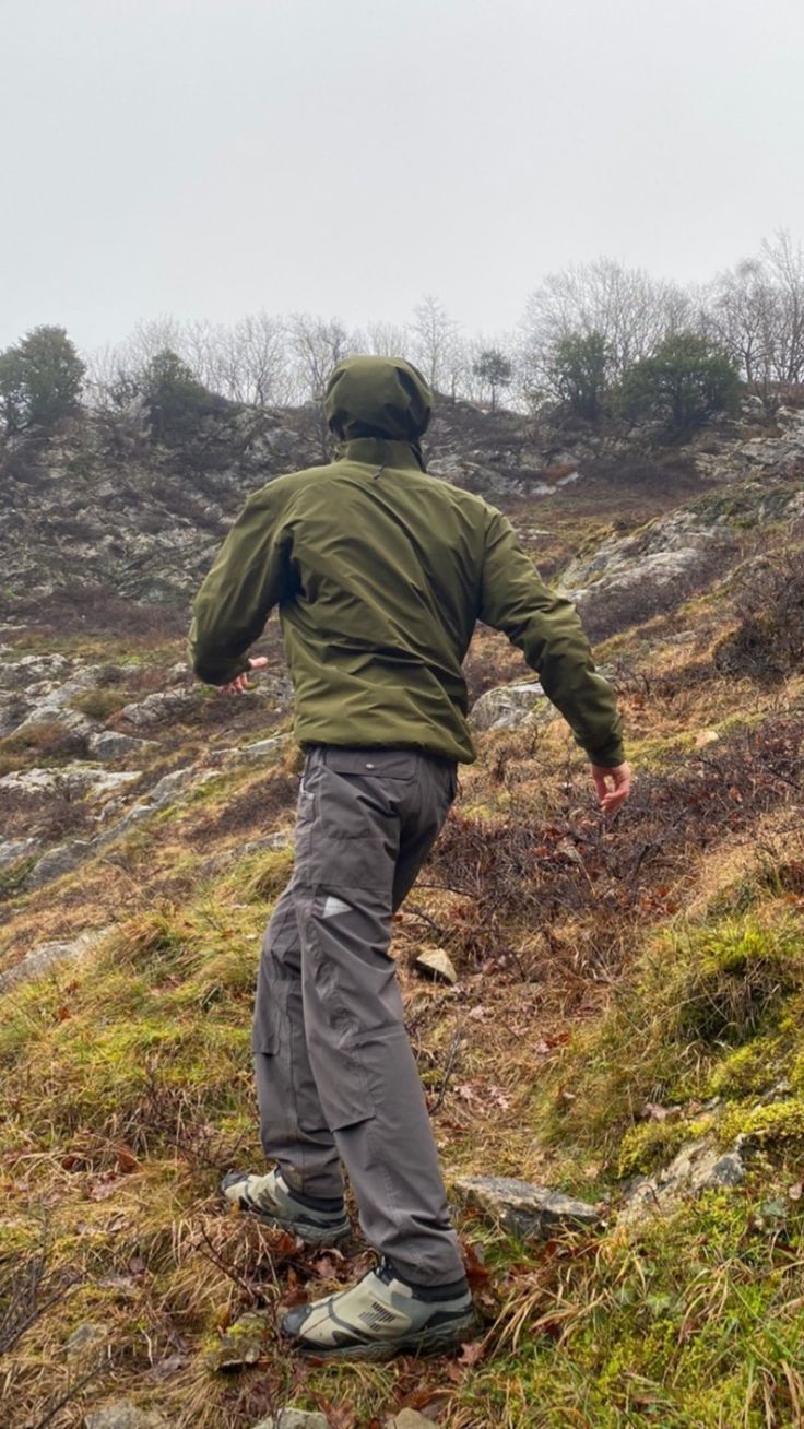 a man walking up a hill in the rain