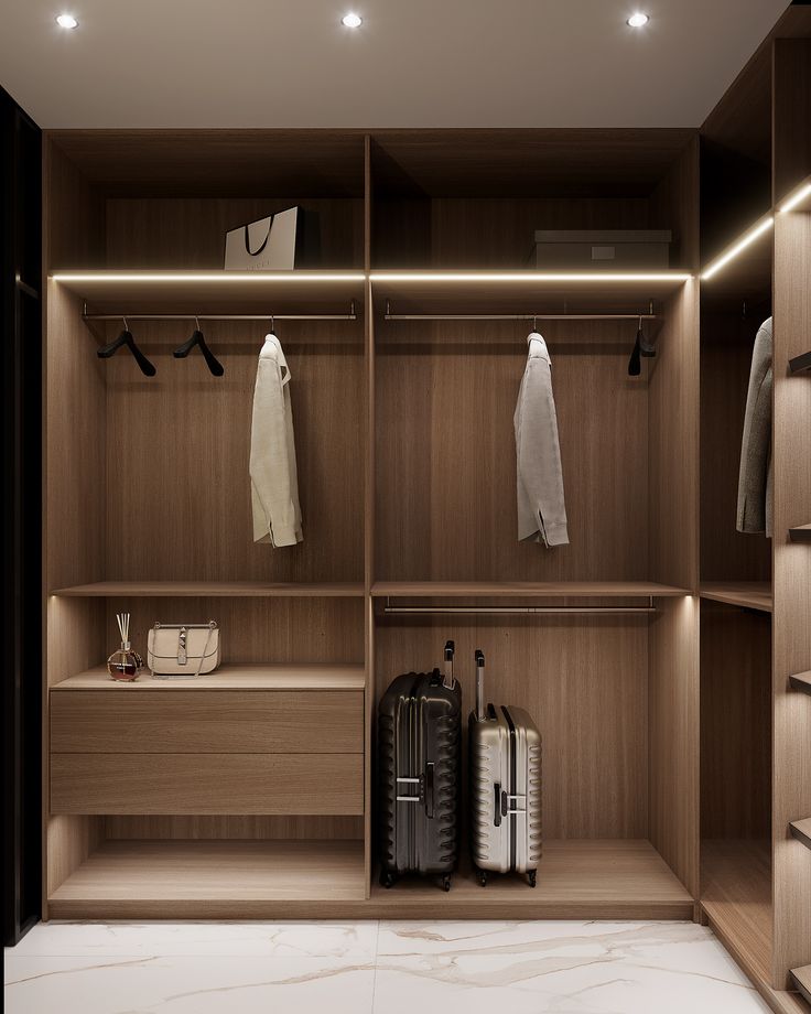 an empty walk - in closet with clothes and luggage on the shelves next to it