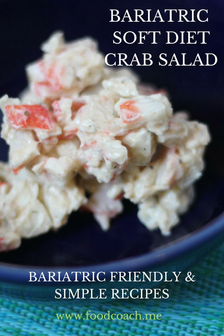 a blue bowl filled with crab salad on top of a table