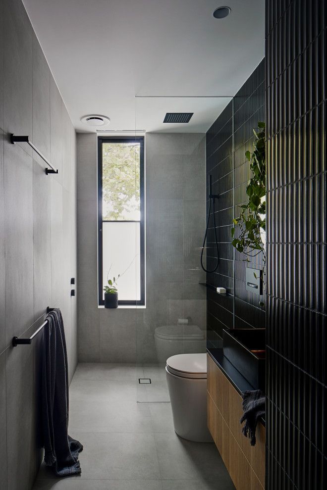 a bathroom with black and white tiles on the walls