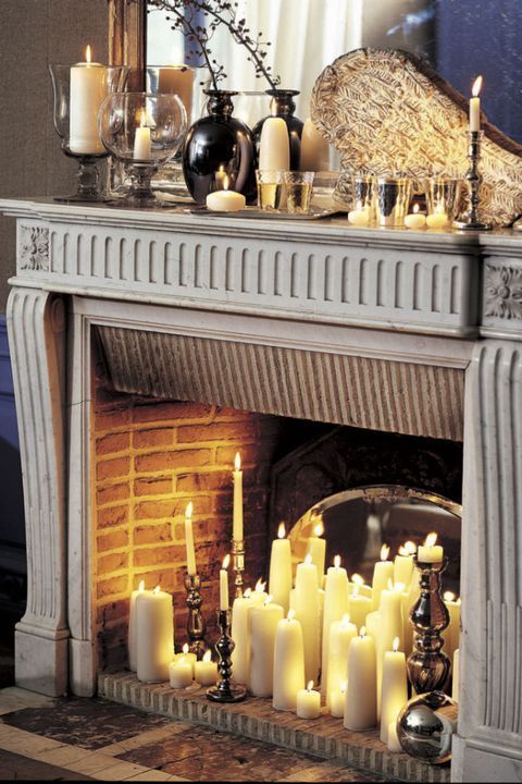 a fireplace with many lit candles in front of it