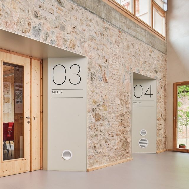 three doors with numbers on them are in front of a stone wall and flooring