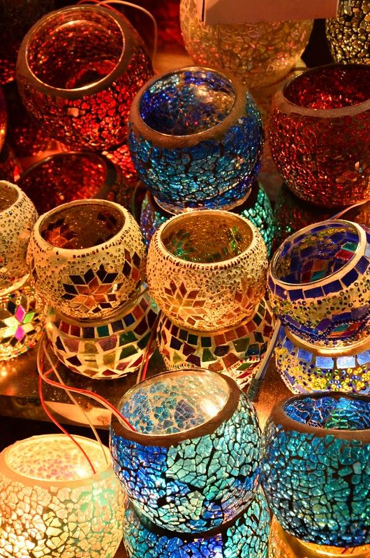 many different colored glass vases sitting on top of a table next to each other