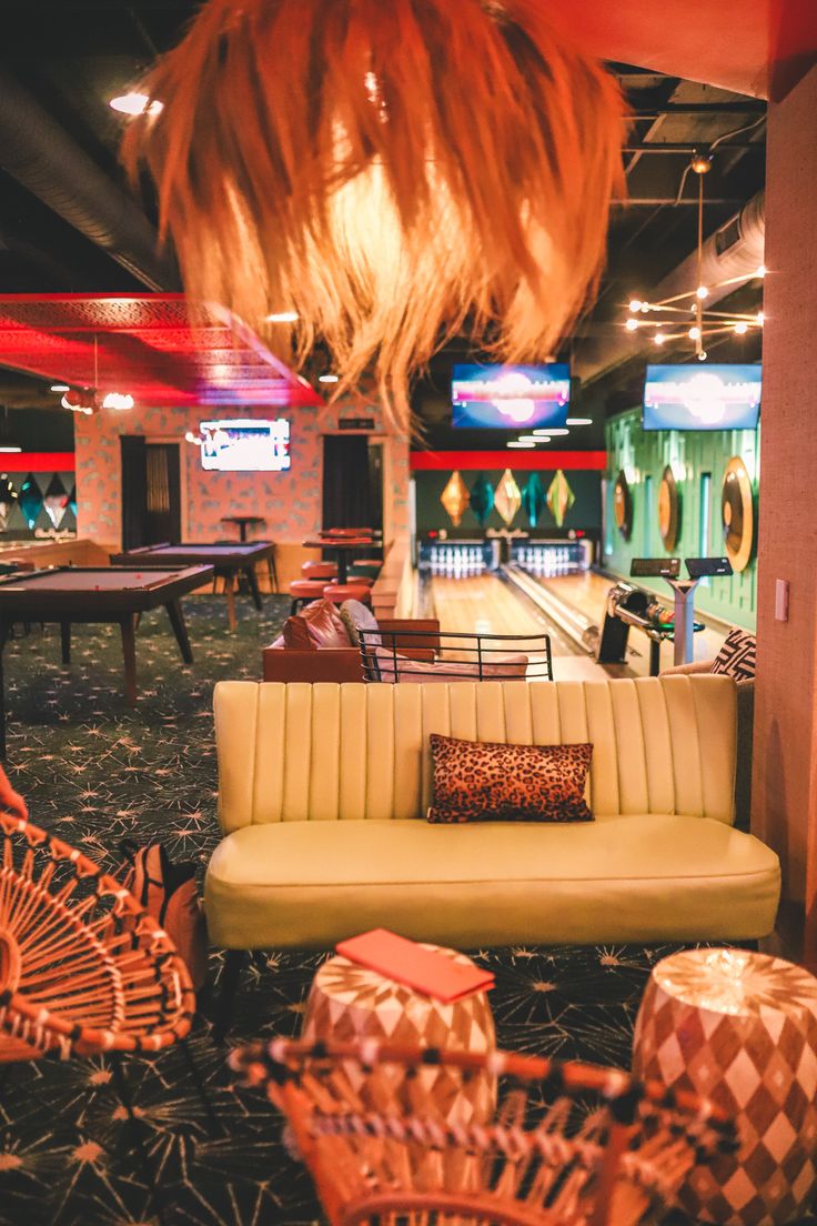 a bowling alley with couches, tables and chairs