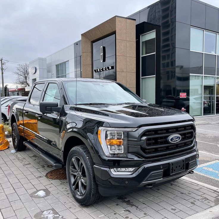 a black truck parked in front of a building