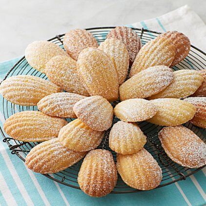 powdered sugar coated almonds in a wire basket on a blue and white tablecloth