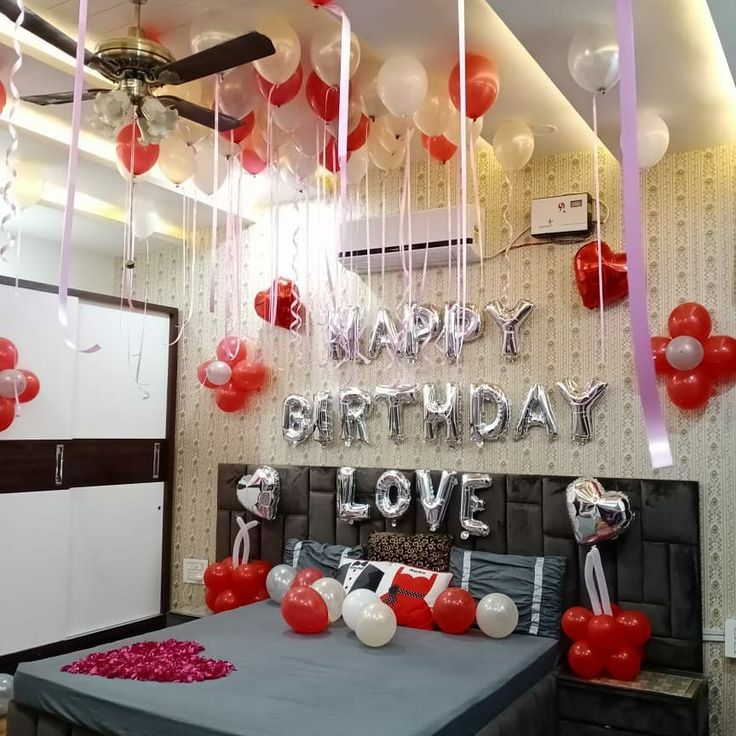 a bedroom decorated for a birthday with balloons and streamers