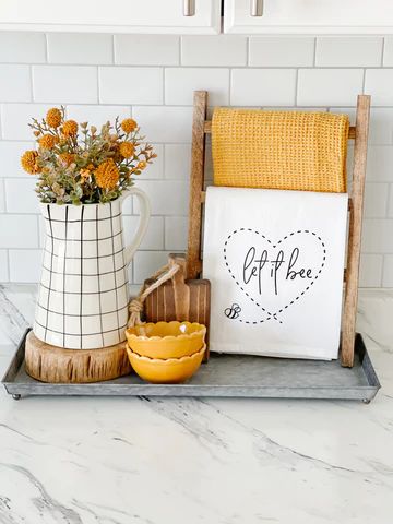 a kitchen counter with flowers in a vase next to a cutting board