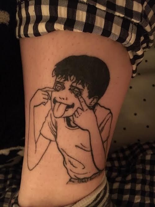 a woman's leg with a black and white drawing of a boy on it