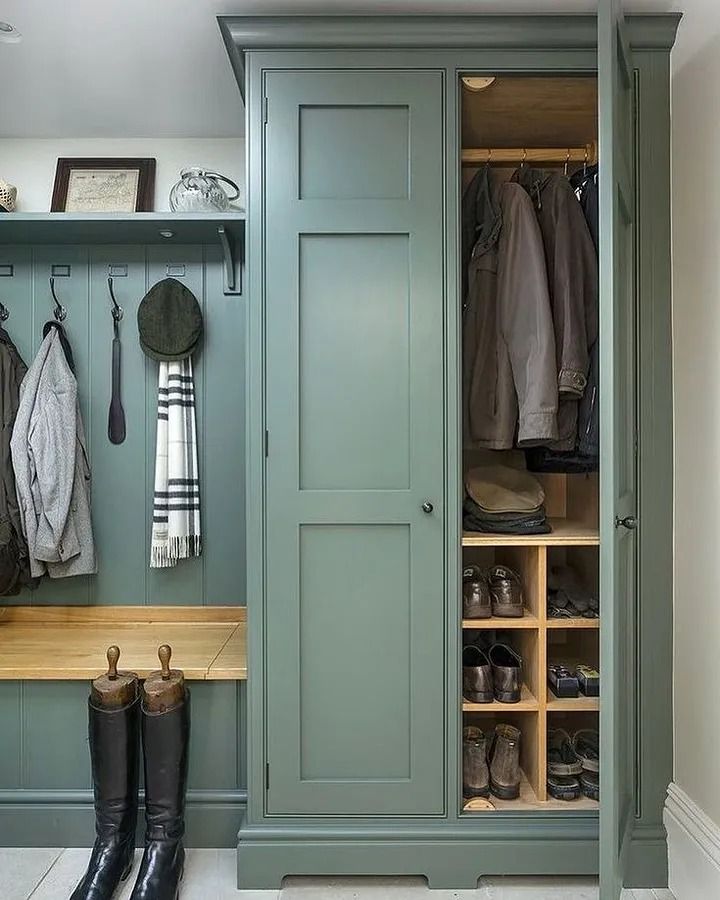 a green closet filled with lots of clothes and boots next to a wooden counter top