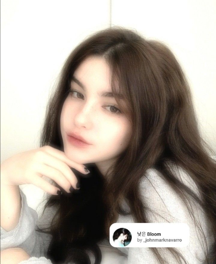 a woman with long brown hair is posing for the camera