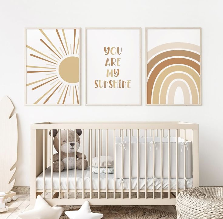 a baby's room with two pictures on the wall and a teddy bear in the crib