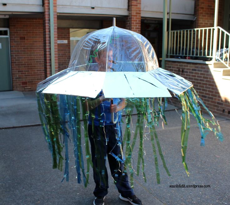 a young boy holding an umbrella made out of plastic