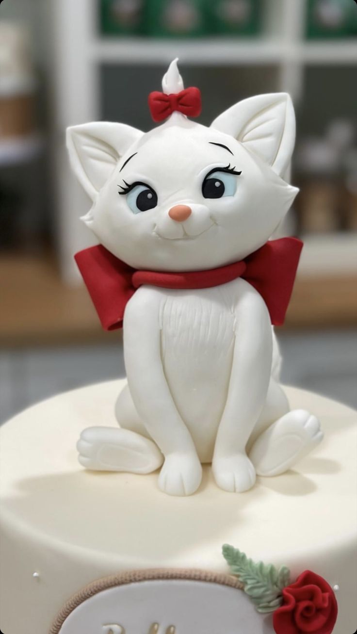 a close up of a cake with a cat figurine on top of it