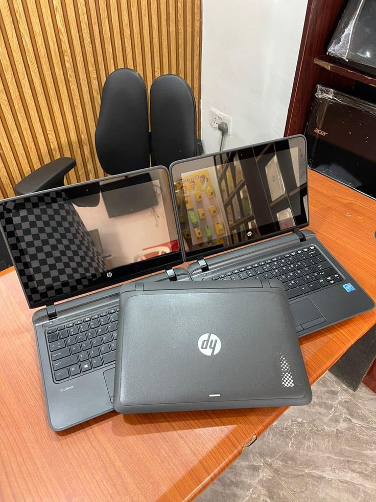 two laptops sitting on top of a wooden table