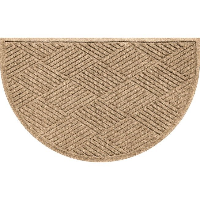 a beige door mat with an oval design on the bottom and sides, in front of a white background