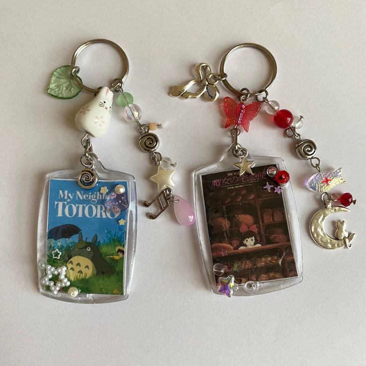 two key chains with pictures and charms attached to them