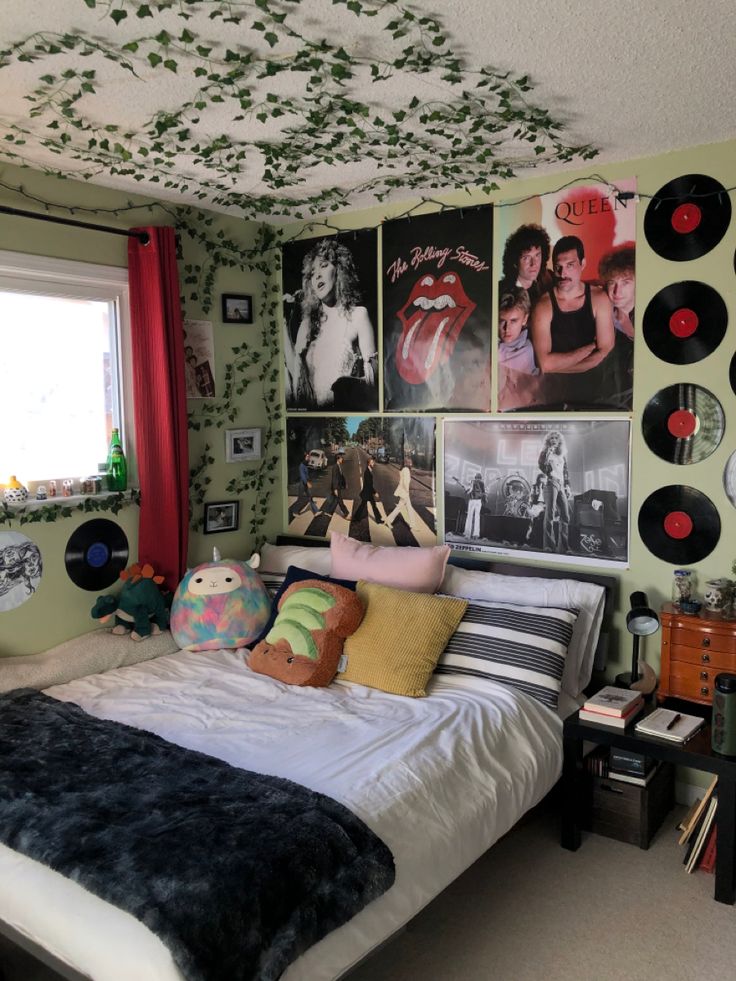 a bedroom with green walls and pictures on the wall above the bed is decorated with vinyl records