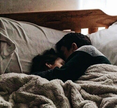 black and white photograph of a man sleeping in bed with his head on the woman's chest