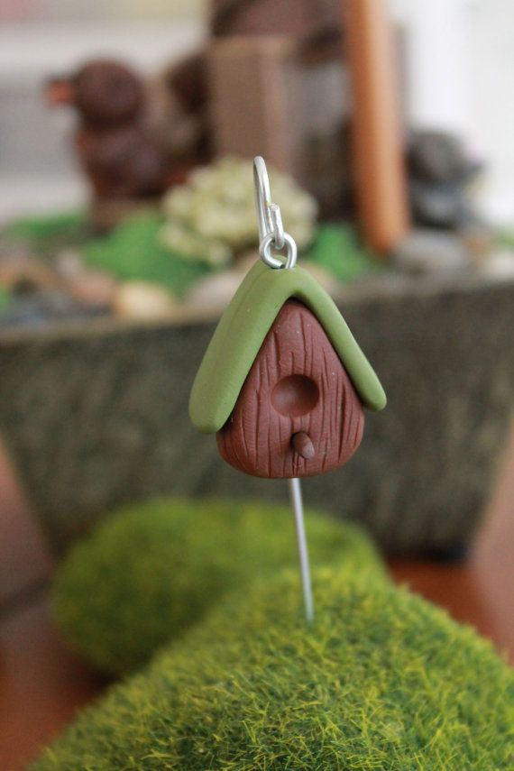 a small birdhouse is hanging from a hook