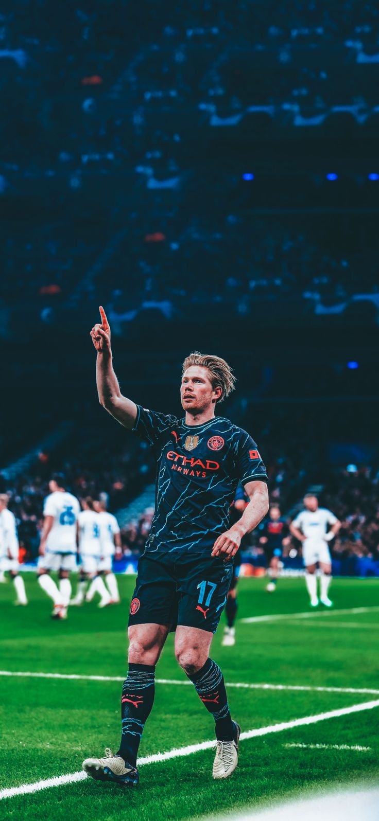 a man standing on top of a soccer field holding his hand up in the air