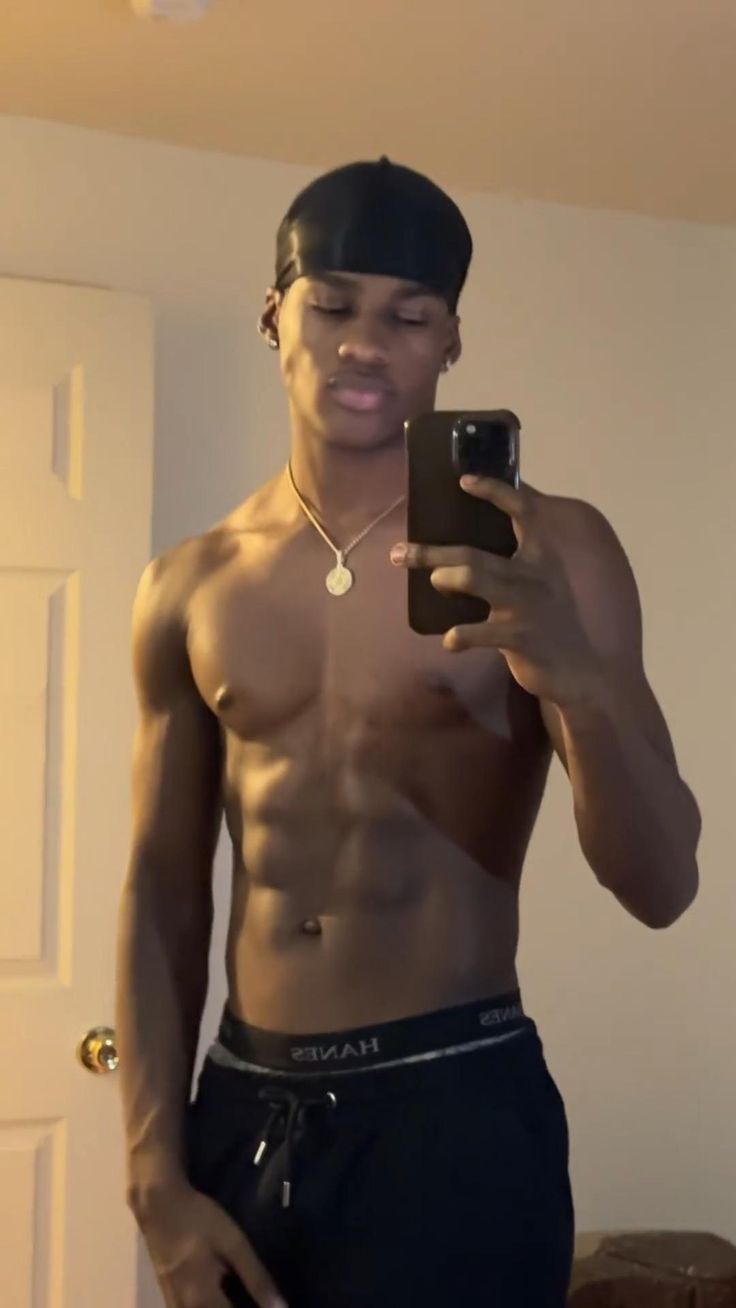 a man with no shirt on taking a selfie in the mirror while holding a cell phone