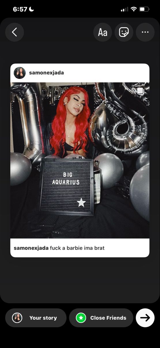 a girl with red hair is holding a black box in front of balloons and heliums