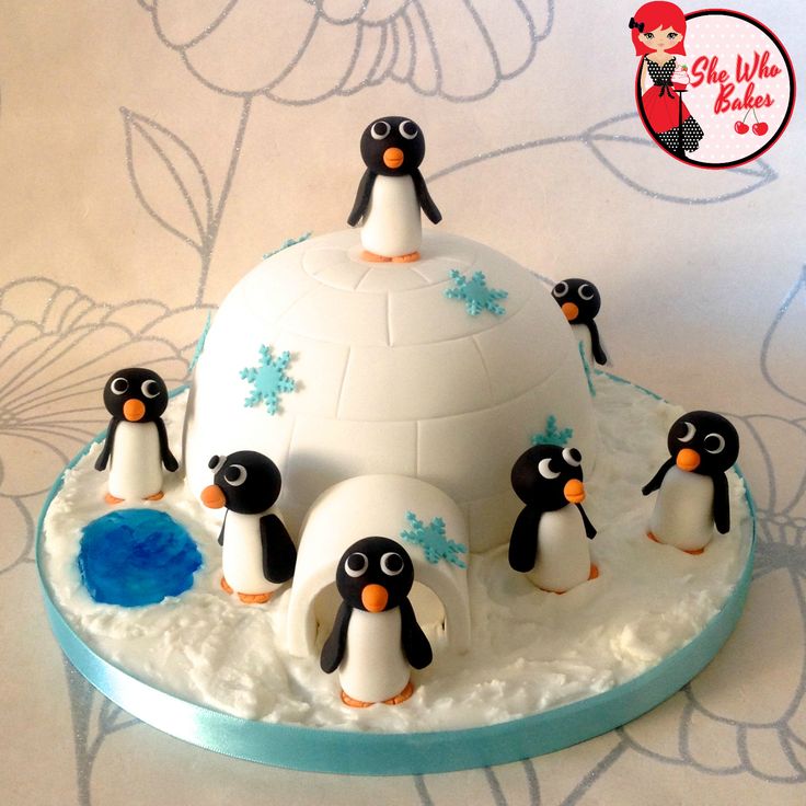 an igloose cake with penguins on it