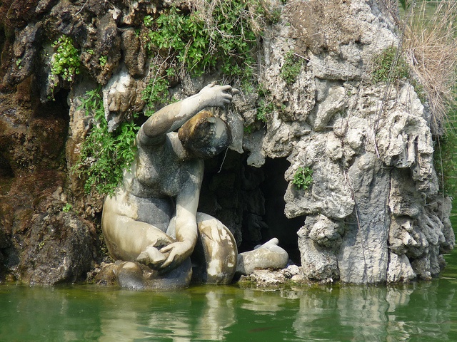 there is a statue in the water with its hands on it's face and head