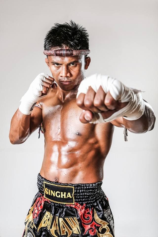 a man with no shirt on posing for a photo in his boxing trunks and gloves