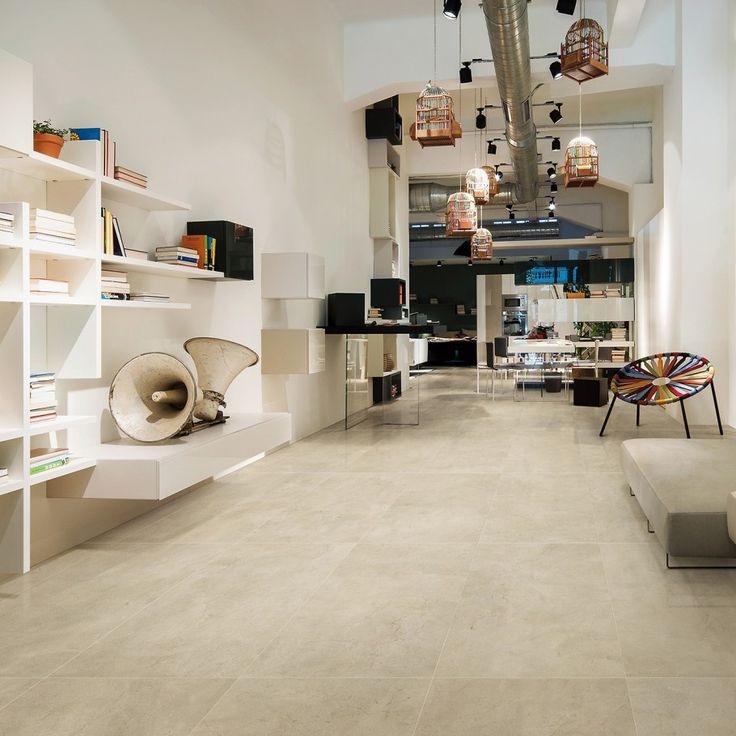 a living room filled with white furniture and lots of bookshelves on the walls